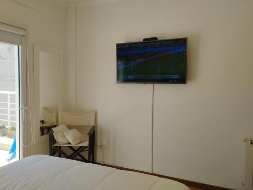 1 dormitorio con 1 cama y TV en la pared en SEMIPISO CON TERRAZA PLAZA MITRE en Mar del Plata