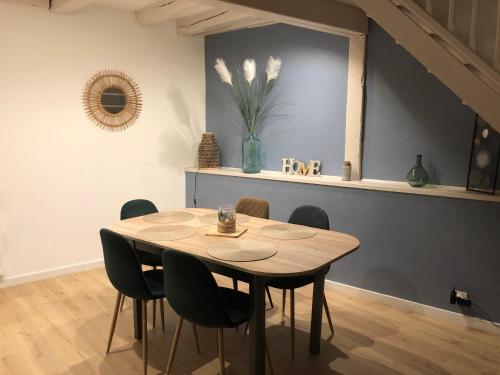 a dining room table with chairs and a vase of flowers at Le 41 Carnot in Poitiers