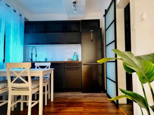 kuchnia ze stołem oraz kuchnia z lodówką w obiekcie Loft w Starej Wozowni w mieście Krynica Zdrój