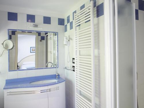 a bathroom with a sink and a mirror at Albergo Milano Snc in Lanzo dʼIntelvi
