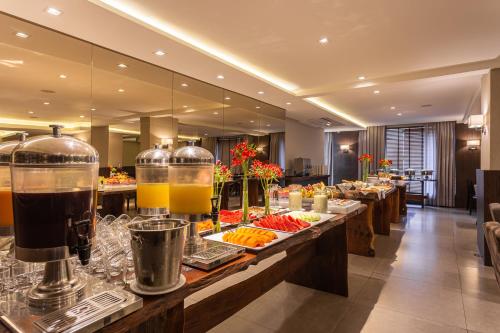 a buffet line with food on display in a hotel at Faial Prime Suítes in Florianópolis