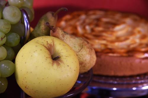 an apple and a bowl of grapes and a pie at Hotel Rioverde in Pralormo