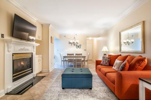 a living room with a orange couch and a fireplace at Dolly Dreams Fireplace Minutes to Dollywood in Pigeon Forge