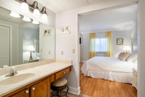 a bedroom with a bed and a sink and a mirror at Dolly Dreams Fireplace Minutes to Dollywood in Pigeon Forge