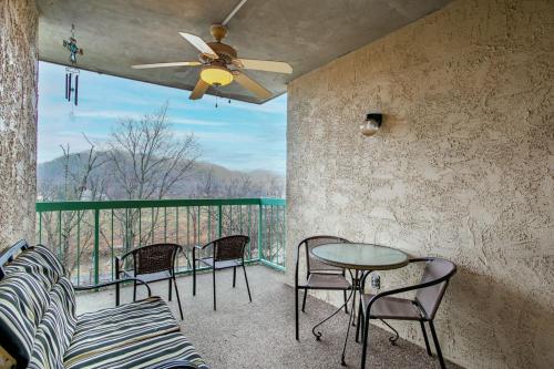 a balcony with chairs and a table and a ceiling fan at Dolly Dreams Fireplace Minutes to Dollywood in Pigeon Forge