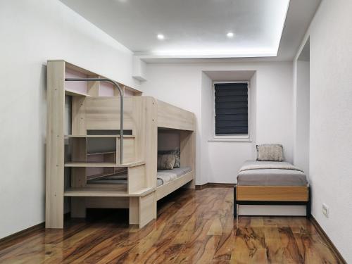 a bedroom with a bunk bed and a chair in it at Stara Pošta Apartment 8 in Grosuplje