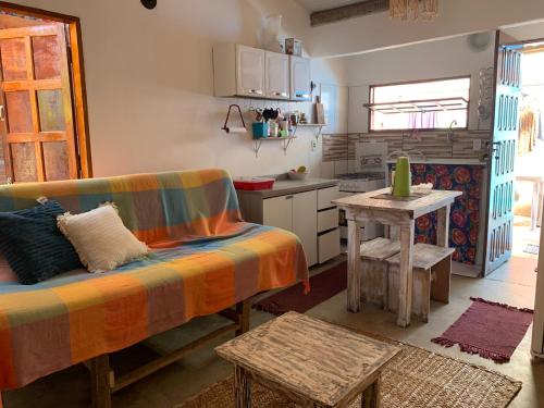 ein Wohnzimmer mit einem Sofa und einer Küche in der Unterkunft Casa da Lua no centro da Vila de Caraíva ao lado da Igreja de Caraíva in Caraíva
