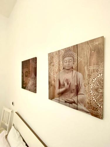 three paintings of a statue on a wall at Villa Elisa in Minturno