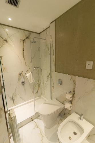 a bathroom with a toilet and a glass shower at Hotel Treinta-Seis in Mar del Plata