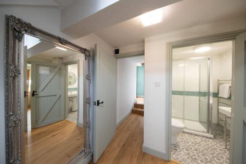 ein Badezimmer mit Spiegel und Toilette in einem Zimmer in der Unterkunft Nadin Cottage in Buxton