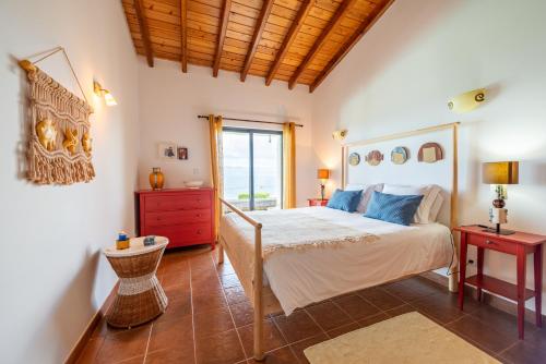 een slaapkamer met een bed en een houten plafond bij A Casa do Jaime in Prainha de Baixo