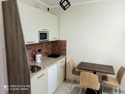 een kleine keuken met een tafel en een magnetron bij Studio Star in Soko Banja