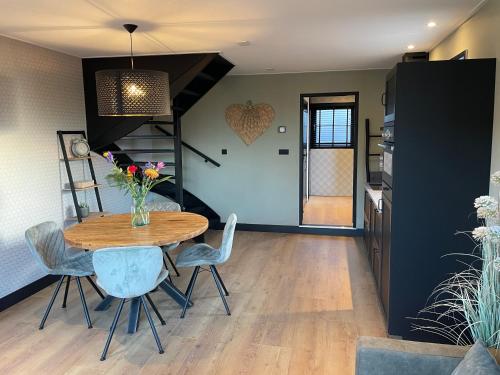 a dining room with a wooden table and chairs at De Heerlykheid Wemeldinge, vlak bij strand en bos, complete woning met eigen tuin in de karakteristieke Dorpsstraat in Wemeldinge