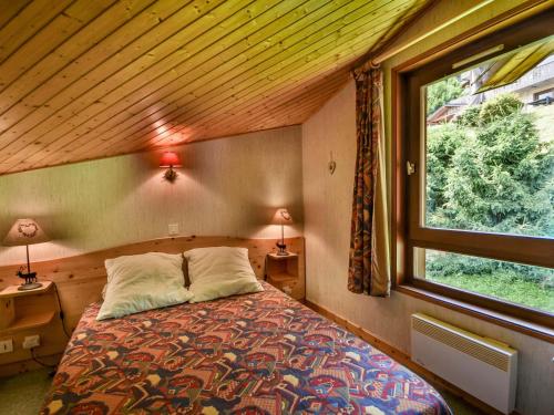 1 dormitorio con 1 cama en una habitación con ventana en Appartement Les Gets, 2 pièces, 5 personnes - FR-1-685-23, en Les Gets