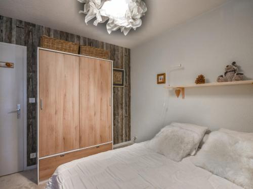 - une chambre avec un lit blanc et une porte en bois dans l'établissement Charmant T2 aux Gets - 4 pers, Proche Pistes, Balcon & Parking - Secteur La Turche - FR-1-685-55, aux Gets