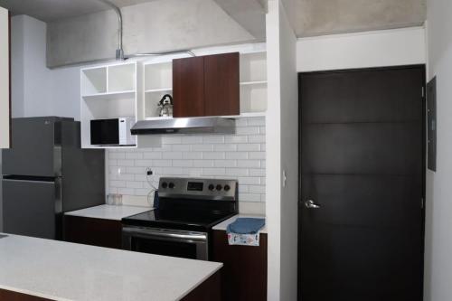 cocina con fogones y puerta negra en Apartamento Citta zona 1, en Guatemala