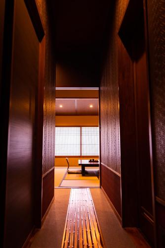 a hallway with a view of a room with a table at Hakone Onsen Ryokan Yaeikan in Hakone