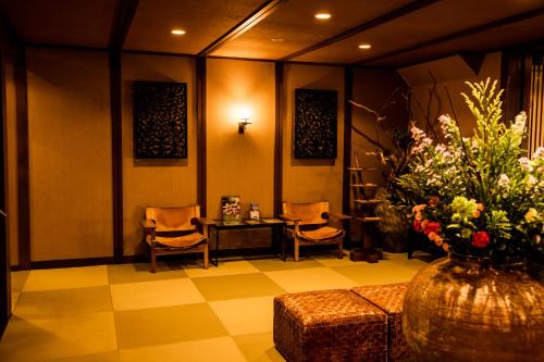 a lobby with a table and chairs and a vase of flowers at Hakone Onsen Ryokan Yaeikan in Hakone