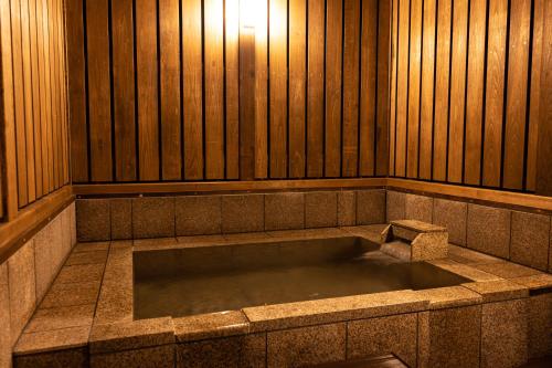 a large bath tub in a room with wooden walls at Hakone Onsen Ryokan Yaeikan in Hakone