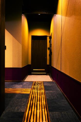 a hallway with a wooden bench in front of a door at Hakone Onsen Ryokan Yaeikan in Hakone