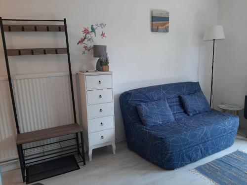 Un dormitorio con una silla azul y una litera en Appartement Seignosse, 1 pièce, 2 personnes - FR-1-239-437, en Seignosse