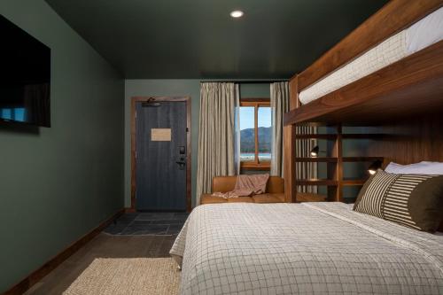a bedroom with a bed and a chair and a window at Hotel Marina Riviera in Big Bear Lake