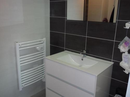 Appartement Les Sables-d'Olonne, 2 pièces, 2 personnes - FR-1-92-593 في لي سابلِ دولونْ: حمام مع حوض أبيض ومرآة