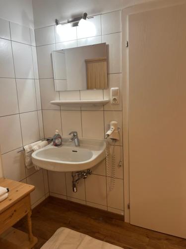 ein Bad mit einem Waschbecken und einem Spiegel in der Unterkunft Ferienwohnung Ingrid Hörbiger in Mittersill