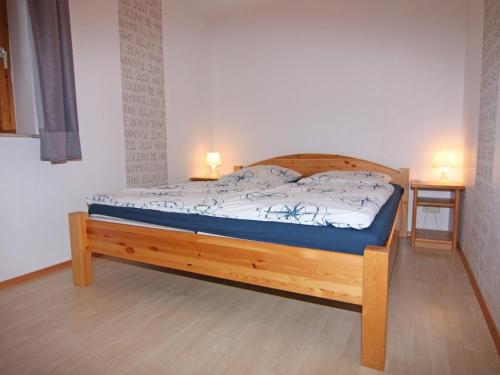a bedroom with a wooden bed with two lamps on it at Gemütliche Ferienwohnung auf Fehmarn in Petersdorf auf Fehmarn