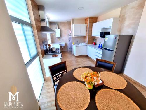 a kitchen and dining room with a table and chairs at Margarita Apartamentos in Cochabamba