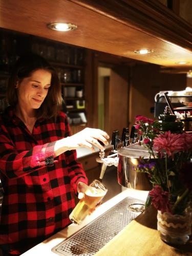 a woman standing in a kitchen preparing food at Moserwirt Pension in Sankt Veit an der Glan