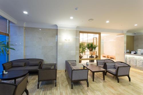 a lobby with tables and chairs and a kitchen at Fontana Beach Hotel in Mokpo