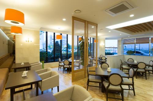 a restaurant with tables and chairs and windows at Fontana Beach Hotel in Mokpo