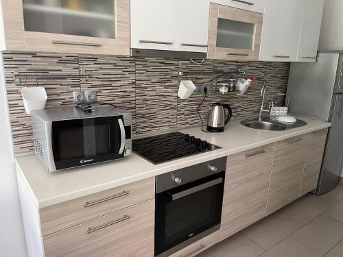 a kitchen with a microwave oven and a sink at At the heart of Plitvice Lakes - Self check-in! in Plitvička Jezera