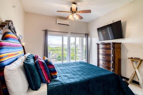 een slaapkamer met een bed en een flatscreen-tv bij Suite A203 @ Mara Laguna in San Pedro