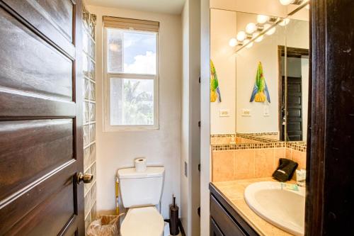 a bathroom with a toilet and a sink and a mirror at Suite A203 @ Mara Laguna in San Pedro