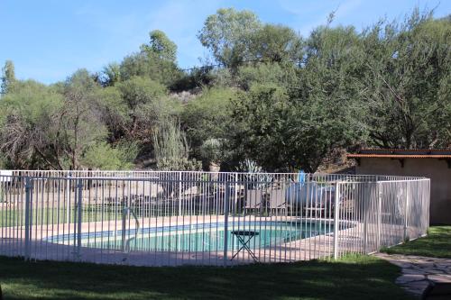 une clôture blanche autour d'une piscine avec une table dans l'établissement Kay El Bar Guest Ranch, à Wickenburg