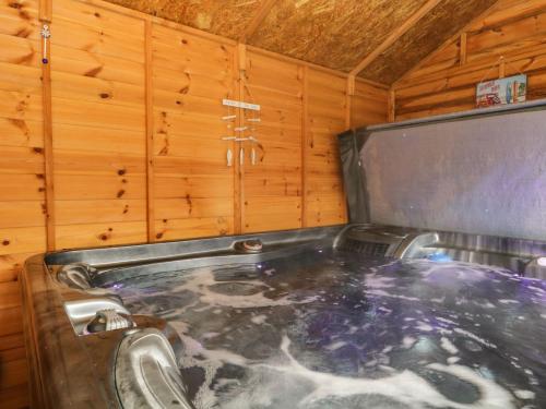 a jacuzzi tub in a room with wooden walls at The Chalet in Egremont