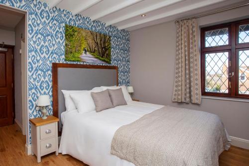 a bedroom with a bed and a blue and white wall at The Woodborough Inn in Winscombe