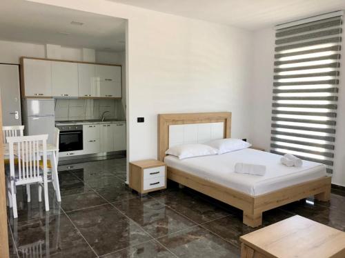 ein Schlafzimmer mit großem Bett und eine Küche in der Unterkunft Era Palace Apartments in Vlorë
