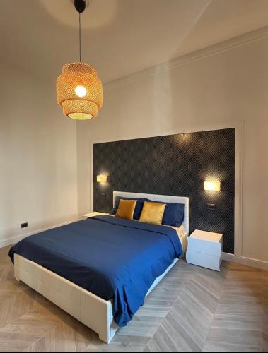 una camera da letto con un grande letto con una coperta blu di Isola suites a Milano