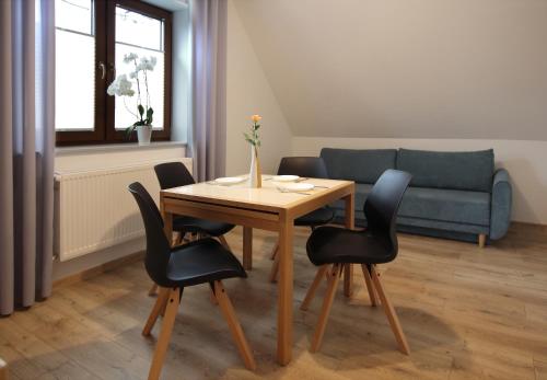 a table and chairs in a living room with a couch at Willa na Plażowej in Węgierska Górka