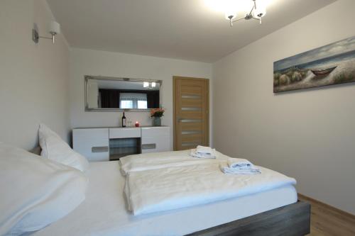 a bedroom with a white bed and a mirror at Willa na Plażowej in Węgierska Górka