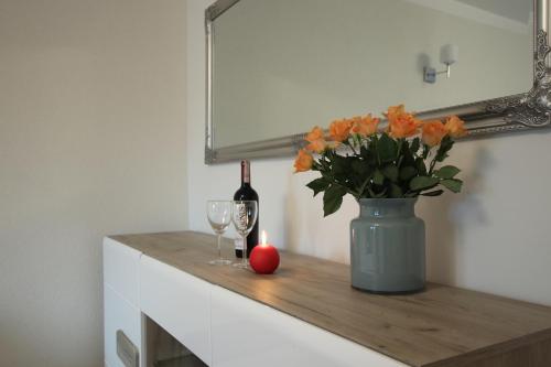 a table with a bottle of wine and a vase with flowers at Willa na Plażowej in Węgierska Górka