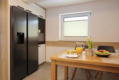 a kitchen with a wooden table and a refrigerator at Willa na Plażowej in Węgierska Górka