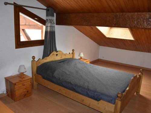 een slaapkamer met een houten bed op zolder bij Chaleureux Appartement 3 Pièces à 400m du Téléphérique - FR-1-464-150 in Pralognan-la-Vanoise