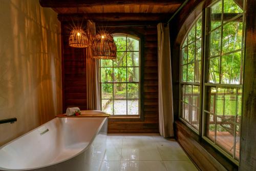 a bathroom with a tub and large windows at Santa María Resort in Santa María del Oro