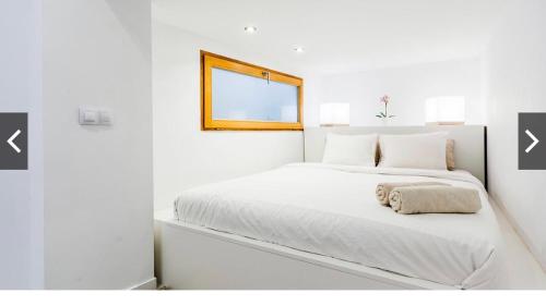 a white bedroom with a white bed with a mirror at Hotel-Apartment Modern Studio in Palma de Mallorca