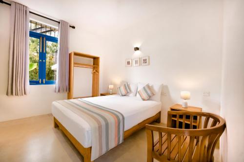 1 dormitorio con cama blanca y ventana en Urchin Unawatuna, en Unawatuna