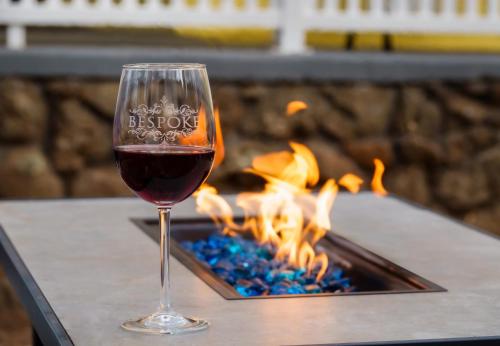 a glass of wine sitting in front of a fireplace at Bespoke Inn Flagstaff in Flagstaff